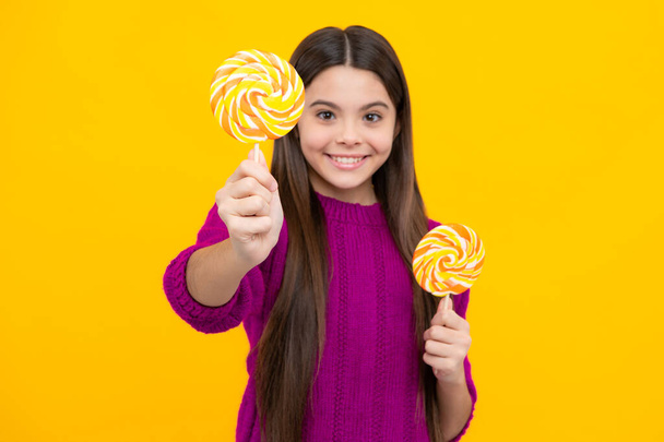 Teenage girl with lollipop, child eating sugar lollipops, kids sweets candy shop - Photo, image