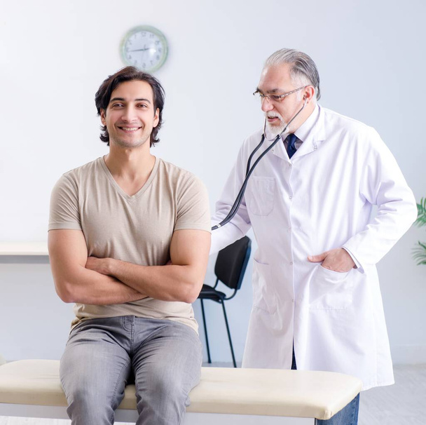 The young male patient visiting old doctor - Photo, image