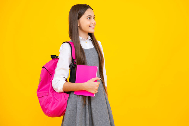 Девочки школьного возраста 12, 13, 14 лет с книгой и тетрадью. Подростковая школьница на изолированном фоне. Концепция обучения и образования - Фото, изображение