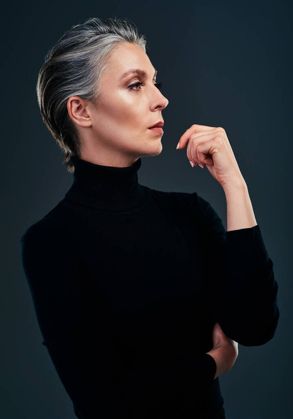 Elegance is when the inside is as beautiful as the outside. Studio shot of a beautiful mature woman posing against a dark background - Zdjęcie, obraz