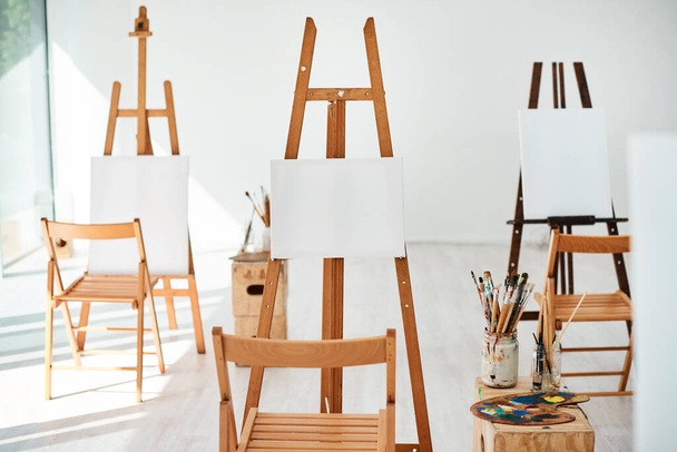 You can choose what to paint. a group of easels and blank canvases in an empty art studio before a painting class - Foto, Bild