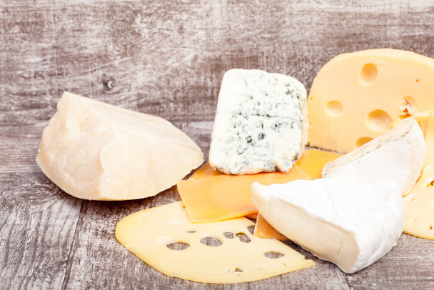 Different type of cheese on wooden background. Gourmet food apetizer - Foto, Imagen