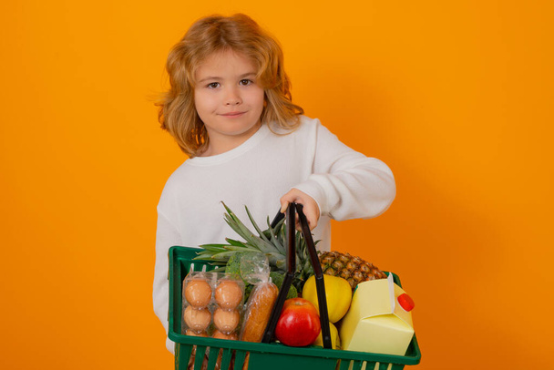 Shopping grocery. Shopping kids. Child buying grocery in supermarket. Grocery store, supermarket. Sale, consumerism and kids concept. Kid boy shopping using basket - Φωτογραφία, εικόνα