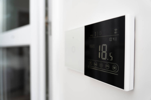 schermo del condizionatore d'aria sulla parete che mostra una temperatura dell'aria di 18 gradi Celsius. un dispositivo per il controllo del riscaldamento a pavimento. - Foto, immagini