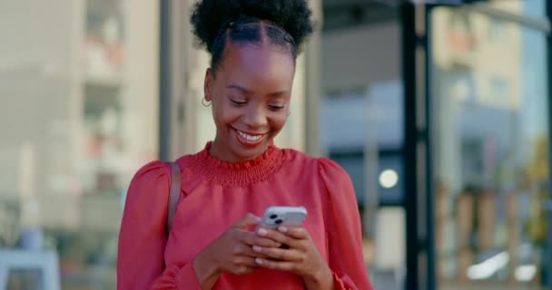 Város, telefon és fekete nő boldogsággal a mobil szövegből és a közösségi média tekercsből. Boldog, városi és mosoly egy afrikai üzleti alkalmazott szabadtéri digitális chat és webes hálózatépítés sms. - Felvétel, videó