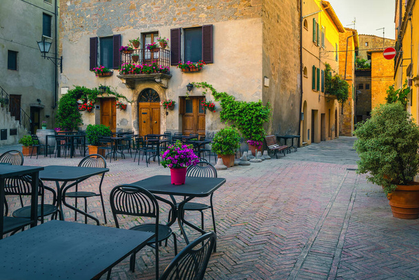 Leuke straat cafe met tafels en stoelen in de oude verharde straat in de vroege ochtend, Pienza, Toscane, Italië, Europa - Foto, afbeelding