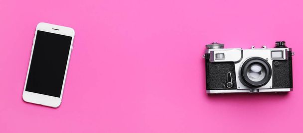 Mobiltelefon és régi fényképezőgép rózsaszín háttér - Fotó, kép