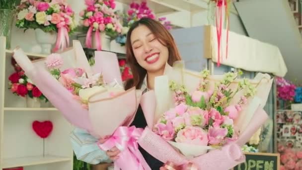 Eine fröhliche Floristin Arbeiterin zeigt schöne Blumensträuße, die in valentine erhalten, glücklich und hell lächelt, arrangiert Arbeit in einem bunten Blumenladen, KMU Unternehmer Person. - Filmmaterial, Video