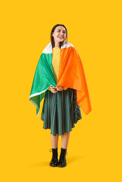 Young woman with flag of Ireland on yellow background - Zdjęcie, obraz