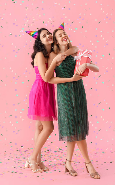 Joyeuses jeunes femmes célébrant l'anniversaire sur fond rose - Photo, image