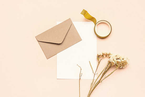 Композиція з конвертом, порожньою карткою, сушеними квітами та клейкою стрічкою на кольоровому фоні
 - Фото, зображення
