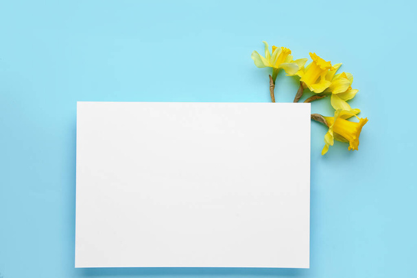 Beautiful narcissus and rectangular blank card on color background - Foto, Bild