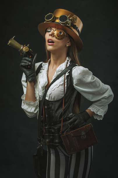 Retrato de una hermosa mujer steampunk sosteniendo un arma
 - Foto, imagen