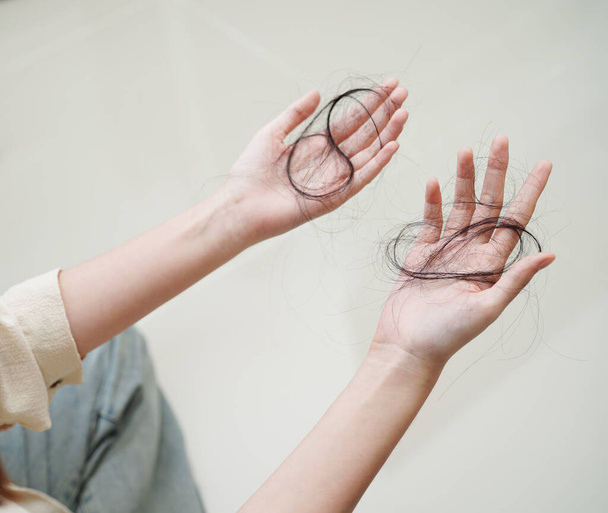 Asian woman have problem with long hair loss attach in her hand. - Fotografie, Obrázek