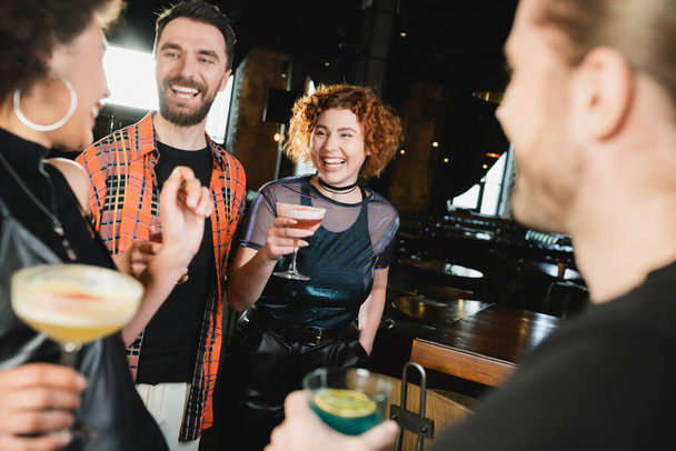 Θετικοί πολυεθνικοί φίλοι με διαφορετικά κοκτέιλ συνάντηση στο μπαρ τη νύχτα  - Φωτογραφία, εικόνα
