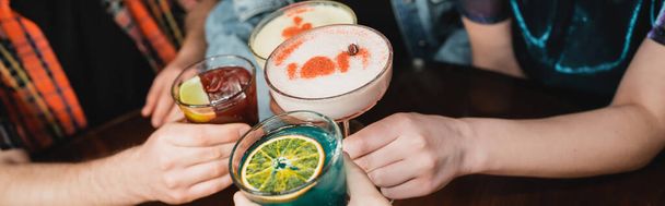 Vista ritagliata di giovani amici che si masturbano con cocktail nel bar di notte, striscione  - Foto, immagini