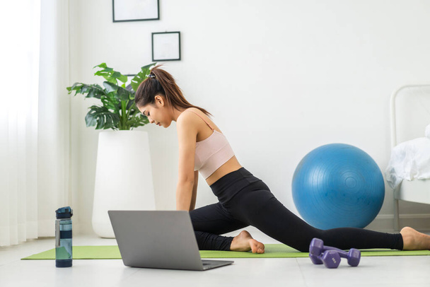 Portré sport ázsiai szépség test karcsú nő sportruházat ül pihenni, és a lány gyakorló jóga és nem fitness gyakorlat laptop számítógép hálószobában.Diéta koncepció.Fitness és egészséges - Fotó, kép