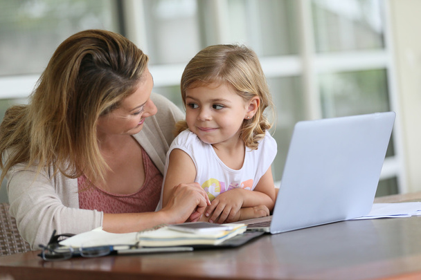 Girl looking at laptop with mother - Φωτογραφία, εικόνα
