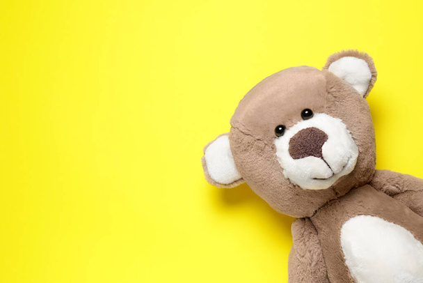 Cute teddy bear on yellow background, top view. Space for text - Фото, зображення