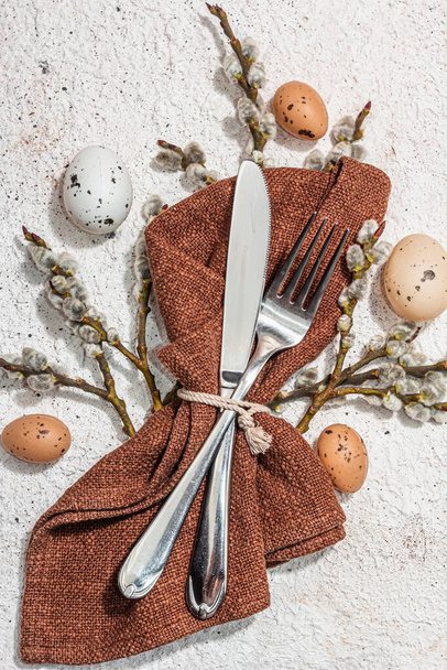 Easter table setting with eggs, rabbits and willow. Traditional festive symbols, greeting card, flat lay. Trendy hard light, dark shadow, plaster background, top view - Fotoğraf, Görsel