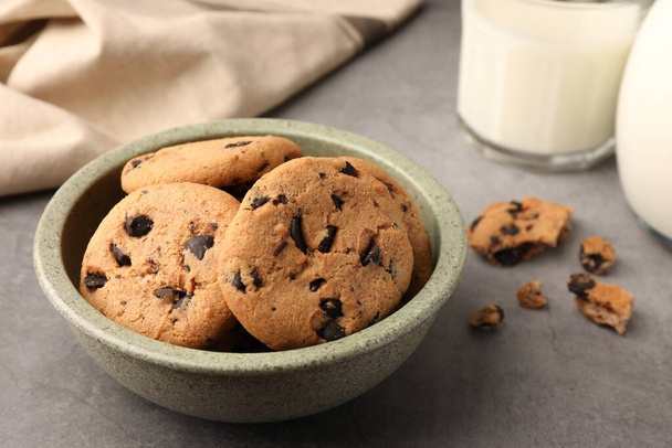 Delicious chocolate chip cookies and milk on grey table - Photo, image