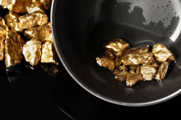 Bowl with gold nuggets on black background, closeup - Zdjęcie, obraz