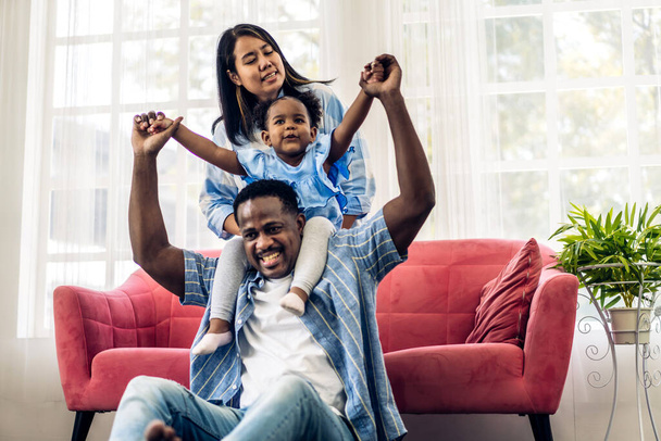 Portrait genießen glückliche Liebe schwarze Familie afrikanisch-amerikanische Vater und Mutter mit kleinen afrikanischen Mädchen Kind lächelnd und spielen Spaß Momente gute Zeit im Zimmer zu Hause - Foto, Bild