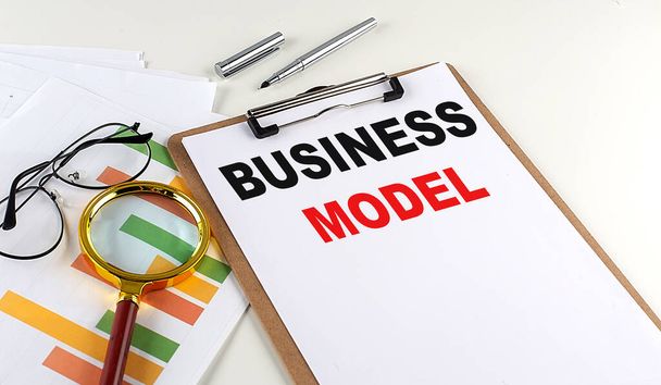 BUSINESS MODEL tekst op een klembord met grafiek op witte achtergrond, business concept - Foto, afbeelding