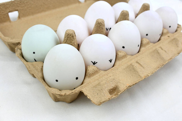 Huevos felices con expresión sonriente en bandeja de cartón. - Foto, imagen