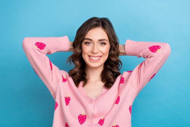 Foto von entspannten jungen Freundin Hände Kopf kühlen zufrieden zahm strahlendes Lächeln Brünette welliges Haar rosa Hemd isoliert auf blauem Hintergrund. - Foto, Bild