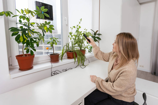 Пилосос чистить вікно робота у високій будівлі на відкритому повітрі. молода жінка контролює пульт
 - Фото, зображення