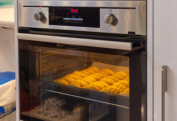 Baking Croissants at Tray in Electric Oven Home Cooking - Foto, afbeelding