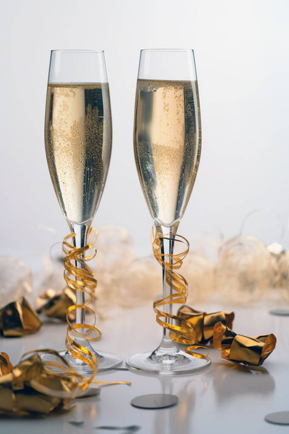 два бокала шампанского на столе в праздничной атмосфере. generated by AI - Фото, изображение