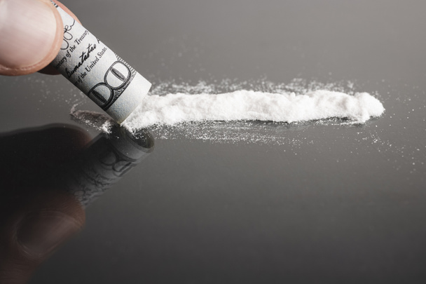 Esnifar cocaína, línea de polvo blanco, billete de dólar enrollado, fondo negro. - Foto, Imagen