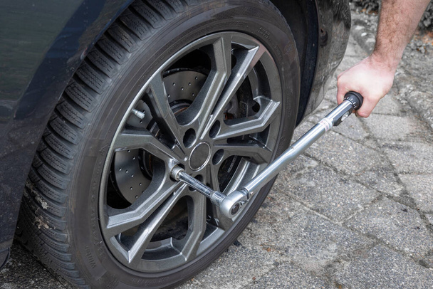 Cambiar los neumáticos del coche y luego reajustarlos al par correcto utilizando una llave dinamométrica, los Países Bajos - Foto, Imagen