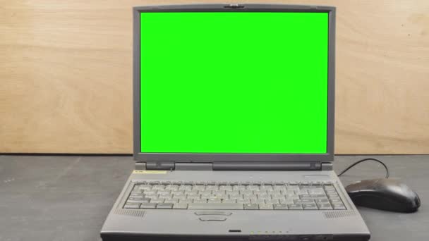 Lap top computer green screen ready for keying. Camera dolly mouse vintage IT old technology. 90's workspace computer laptop on a black table, wood grain background vintage old IT technology. Easy to key out green screen, easy to track. - Footage, Video