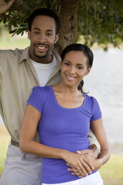 Happy African American Couple Holding Hands Under A Tree - Фото, изображение