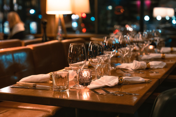 Ρετρό εστιατόριο μακρύ τραπεζαρία ρύθμιση τραπέζι με ασημικά και ποτήρια κρασιού για την τροφοδοσία σε πολυτελές εστιατόριο - Φωτογραφία, εικόνα