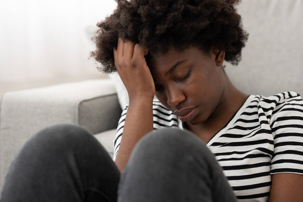 Aşırı düşünen üzgün Afrikalı Amerikalı genç bir kadının yakın çekimi. Depresyon ve yas kavramı - Fotoğraf, Görsel