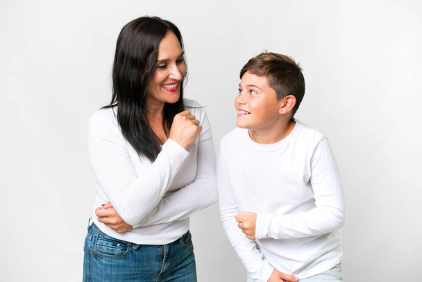 Little caucasian kid with his mother over isolated white background smiling a lot - Фото, зображення