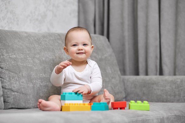 cute baby girl playing with colorful toy blocks at home. Early development for kids. - Фото, зображення