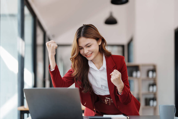 Gyönyörű fiatal tini ázsiai üzletasszonyok segítségével számítógépes laptop kezét fel a győztes gesztus, Boldog, hogy sikeres ünnepli teljesítmény siker. - Fotó, kép