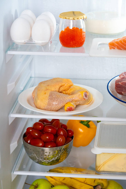 Refrigerator with healthy food. Refrigerator with meat, fish, chicken, red caviar, steaks, vegetables, fruits, eggs. Fridge full of healthy food only. Diet with protein. Refrigerator with protein diet. - Photo, Image