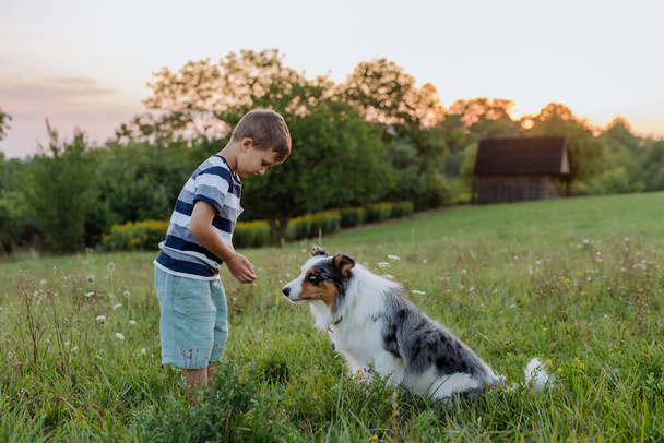 LIttle boy with his dog in nature. - Foto, imagen