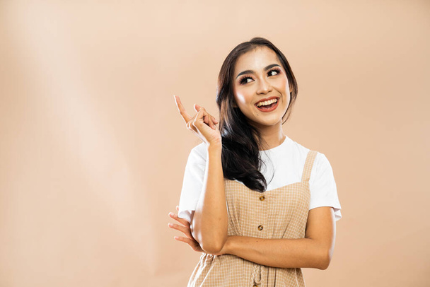 asian woman in casual clothes standing with smile while looking and pointing up on isolated background - Foto, immagini