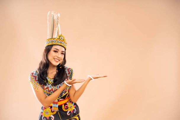 asian woman in king bibinge standing with smile and pointing on empty space at her left side on isolated background - Foto, Bild