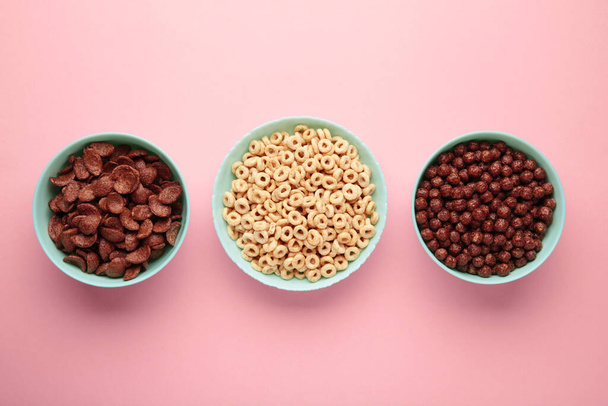 Set of various breakfast cereals on pink background, top view - Фото, изображение
