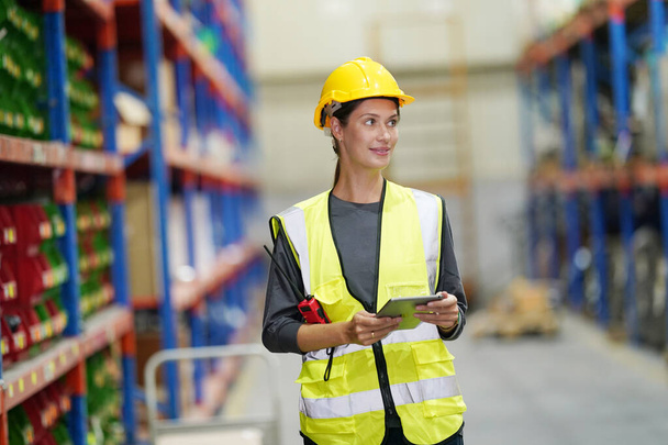 Warehouse Industriële supply chain en Logistiek Bedrijven binnen. Pakhuispersoneel controleert de inventaris. Producten op voorraadplanken. - Foto, afbeelding
