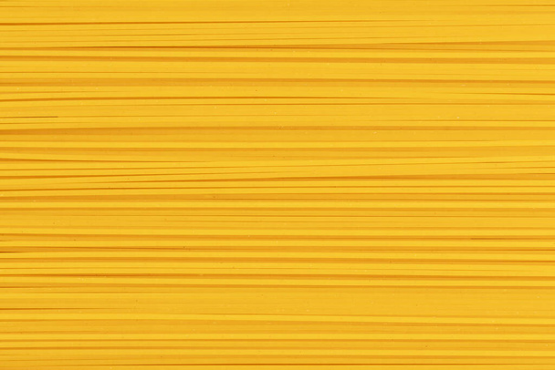 Raw spaghetti. Uncooked durum pasta. Full frame of noodles. Food background. - Photo, Image