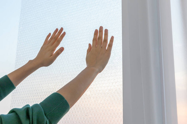 DIY interior hand motion, closeup_putting an air cap on the window - Foto, Bild